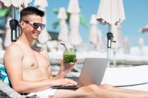 man-beach-using-laptop